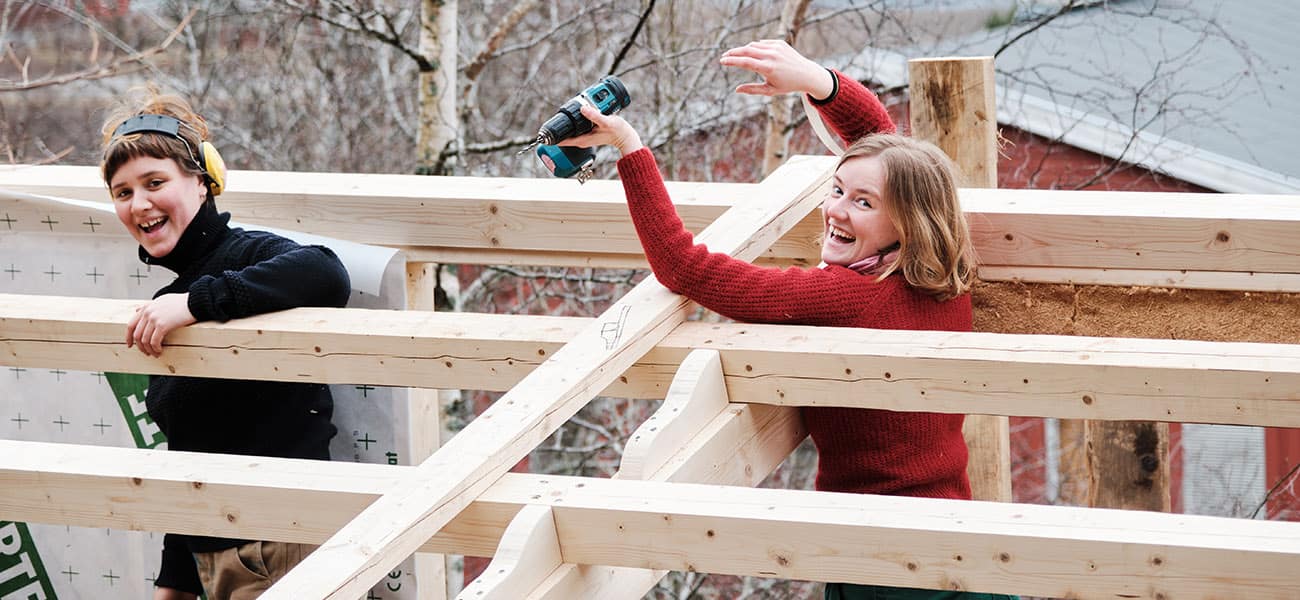 Two students constructing the roof for a tiny house