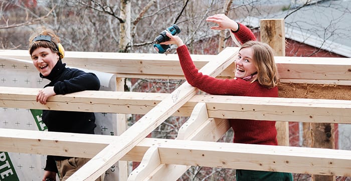 Two girls constructing a tiny house roof