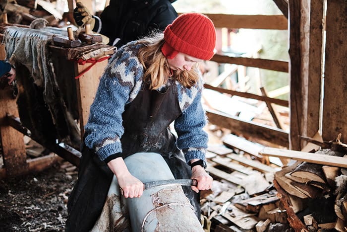 Student scraping a sheep hide before tanning