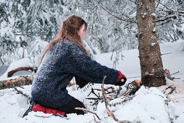 Female student cutting a tree using a saw