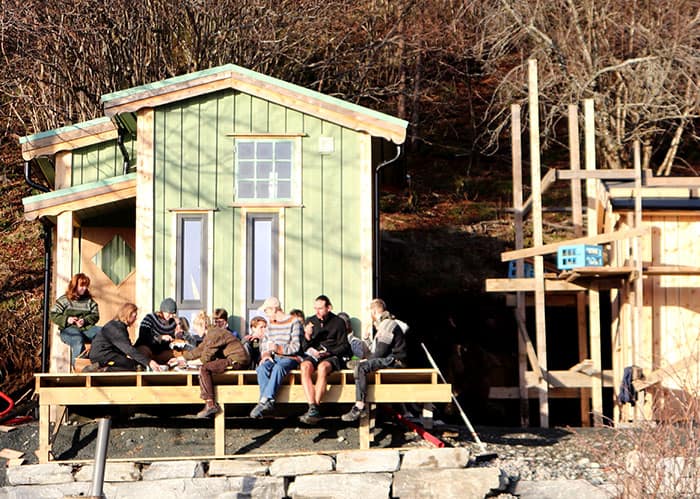 The tiny house class taking a coffee break in front of one of the tiny houses